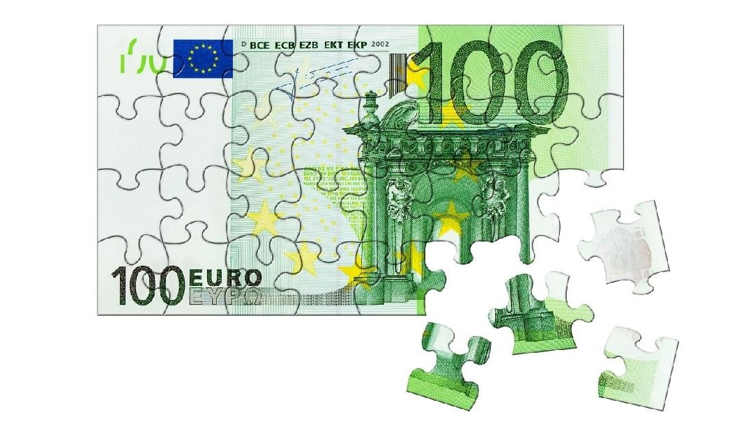 Ein Hundert-Euro-Schein als Puzzle, an der unteren rechten Ecke sind vier Puzzleteile herausgetrennt | Immobilienfinanzierung